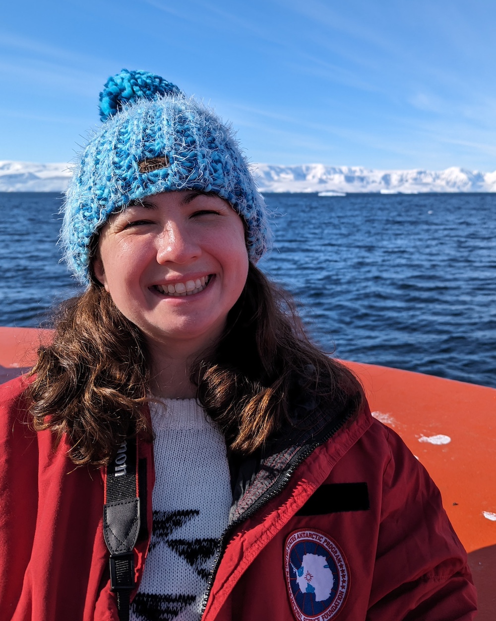 Floback smiles on a ship in front of Antarctica.