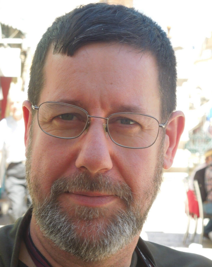 A close-cropped image shows Ricardo peering at the camera behind wire-rimmed glasses.